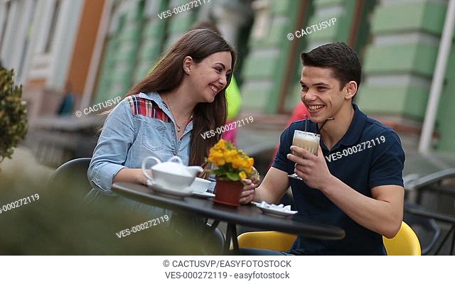 Young couple enjoying romantic date in street cafe