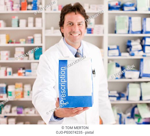 Pharmacist holding prescription in drug store