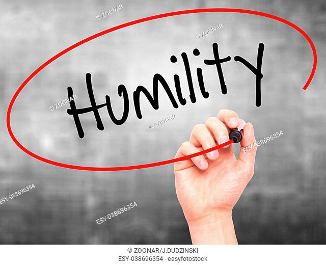 Man Hand writing Humility with black marker on visual screen