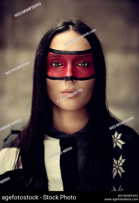 Serious woman with red paint on face