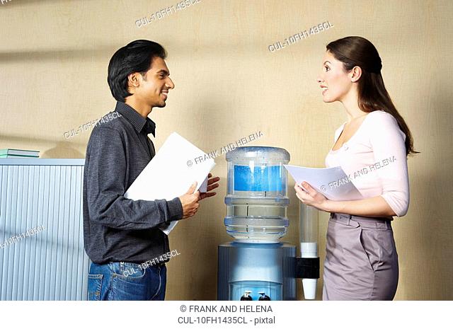 Man and woman chatting by water cooler