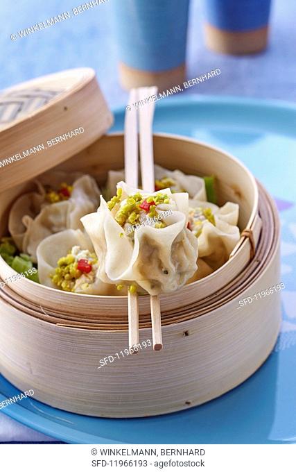 Wontons filled with chicken and pistachio nuts in a steamer basket