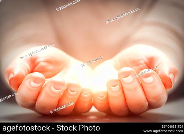 Light in woman#39;s hands. Concepts of sharing, giving, offering, new life