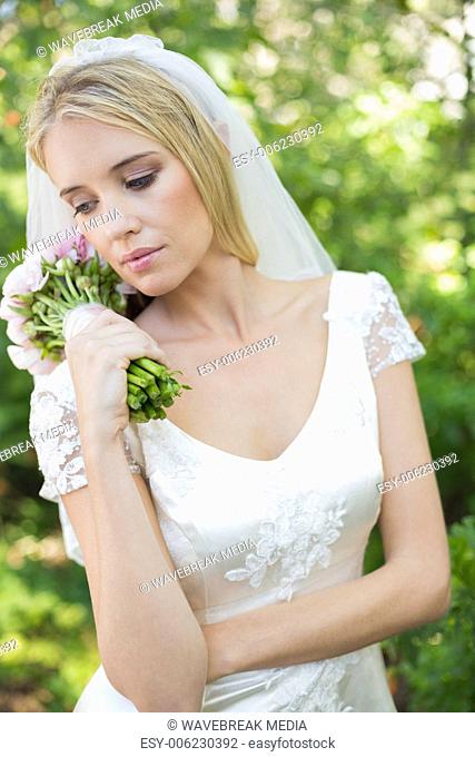 Content bride holding her bouquet wearing a veil