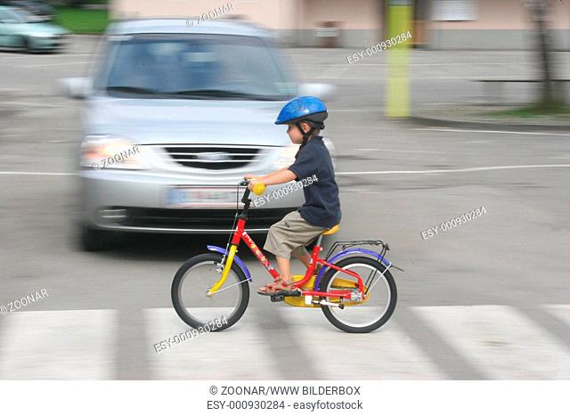 Kind mit Fahrrad auf Schutzweg / Child with a bicycle on pedestrian crossing