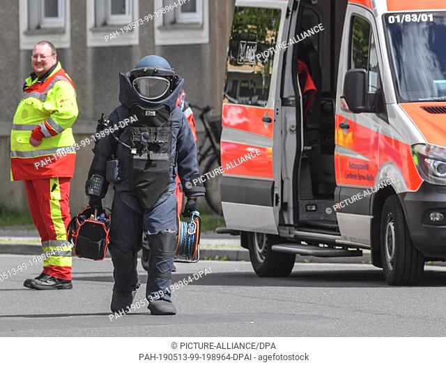 13 May 2019, Brandenburg, Forst: An explosives expert walks across the closed Amtstrasse in protective equipment. Two male corpses have been discovered in an...