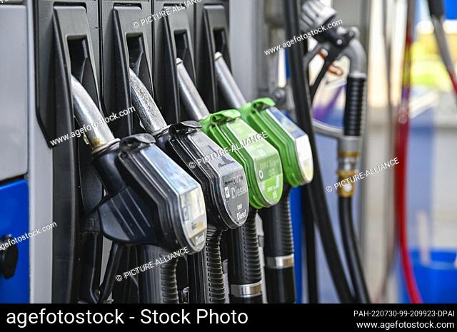 29 July 2022, Bavaria, Rosenheim: Petrol pump nozzles at an OMV service station. Those who want to save money at the gas station while on vacation abroad will...