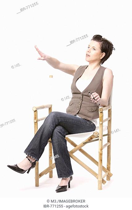 A woman sitting in a director's chair and giving orders