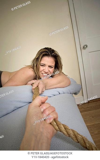Woman in bed pulling on a rope