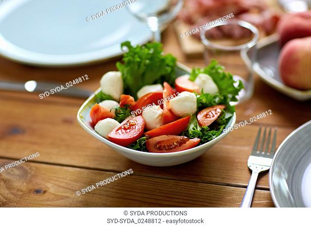 vegetable salad with mozzarella on wooden table