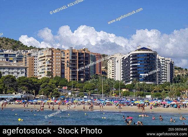 Vacationers in front of high-rise buildings in the water and on the beach of Cala Finestrat, Alicante, Spain on September 12, 2020