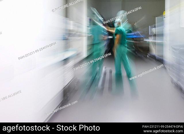 PRODUCTION - 29 November 2023, Schleswig-Holstein, Rendsburg: Nursing staff and doctors talk in a corridor in the operating center of the Schön Klinik