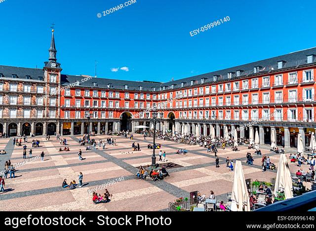 Madrid, Spain - April, 18 2021: People enjoying in restaurant terraces in Plaza Mayor Square in Madrid. View during restrctions for coronavirus covid-19...