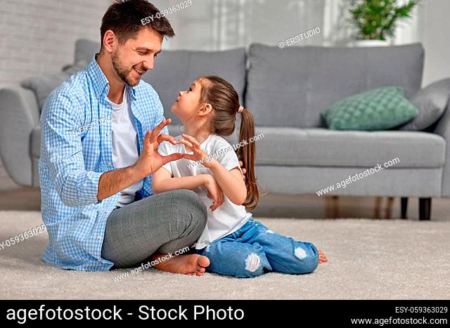 handsome father and cute little child daughter showing love sign. dad and girl kid make hand heart gesture. Happy Father's day