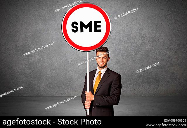 Young business person holdig traffic sign with SME abbreviation, technology solution concept