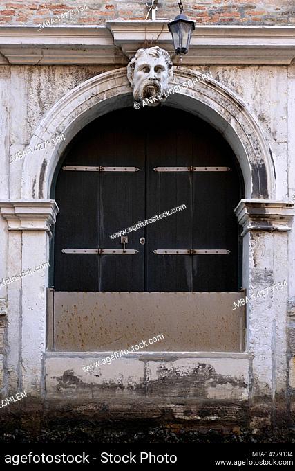 Weathered Venetian arched door in the old town of Venice, Italy