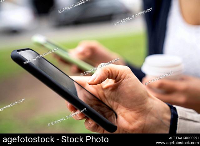 Close-up shot of two women's hands holding smartphones