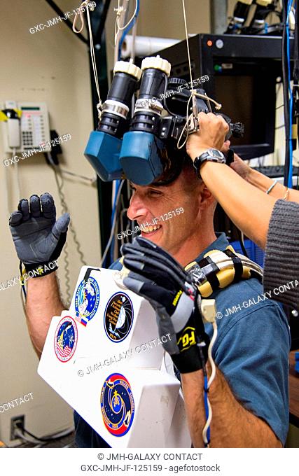 NASA astronaut Michael Hopkins, Expedition 3738 flight engineer, prepares to use virtual reality hardware in the Space Vehicle Mockup Facility at NASA's Johnson...