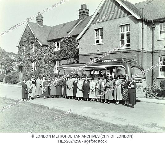 Group of women visitors in front of the ivy-clad Shirely Residential School, Croydon, 1937. Female visitors standing in front of a Pullman coach