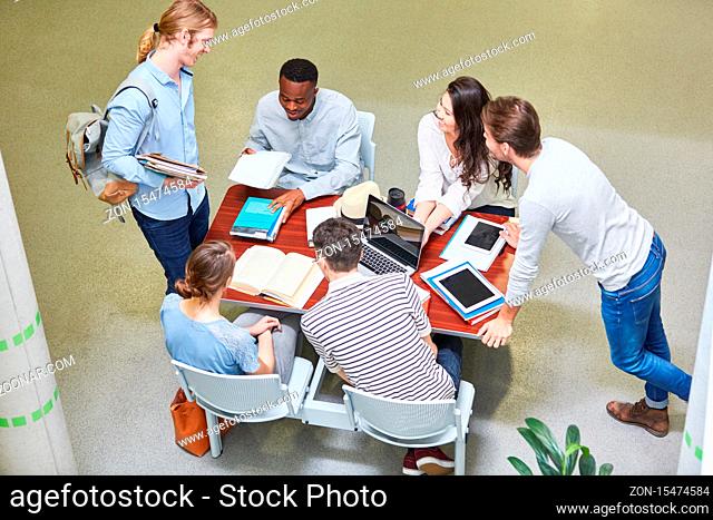 Glückliche Gruppe Studenten am Tisch in einer Universität beim Lernen