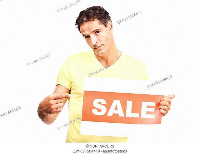 Portrait of serious mature guy pointing at sale sign in his hand isolated against white background