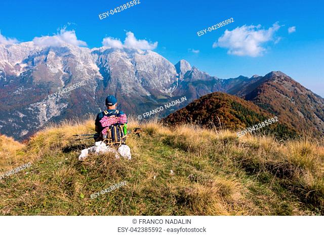 Man hiker sit and watch the landscape of mountain in autumn from the mountain top