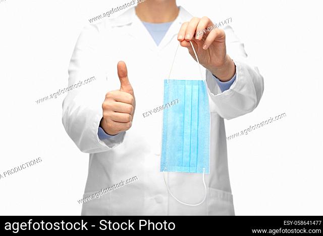female doctor with medical mask showing thumbs up