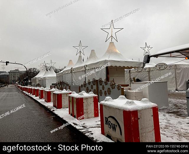 02 December 2023, Hamburg: Red and white concrete blocks are set up along a street in front of a Christmas market. Following the latest arrests for allegedly...