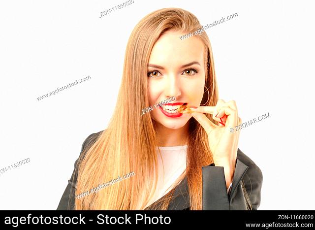 Pretty woman tasting a golden bitcoin coin on her tooth