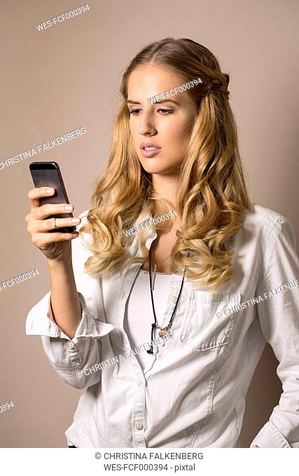 Portrait of young woman reading SMS
