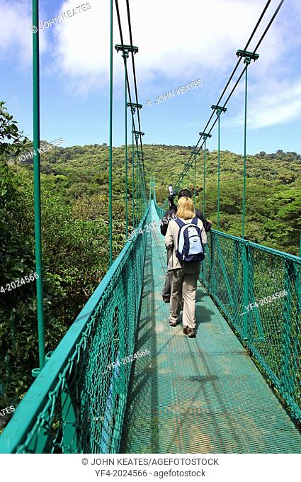 A tourist and guide on One of the hanging bridges suspension bridge over the cloud forest canopy at Monteverde Cloud Forest, Costa Rica, Central America