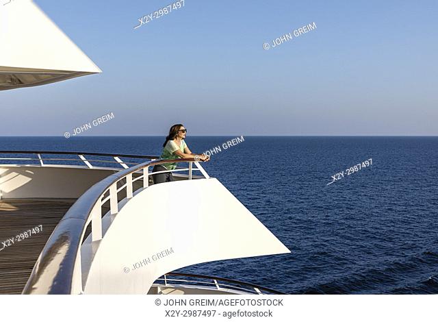 Woman enjoys the ocean view from a yacht deck
