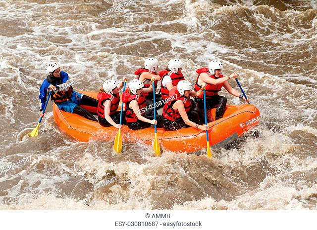 Group Of Mixed Tourist Men And Women With Guided By Professional Pilot On Whitewater River Rafting In Ecuador
