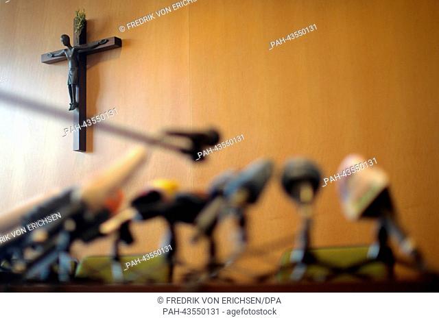 Microphones stand on a table in front of a crucifix at the wall before a press conference in the episcopal seminary in Limburg An Der Lahn, Germany