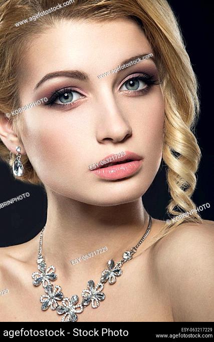 Beautiful girl with perfect skin and evening makeup. Portrait shot in the studio on a black background