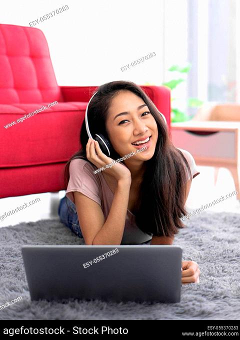 Teen wearing headphones listening to music relax in living room, enjoy leisure weekend at home. Stress free concept