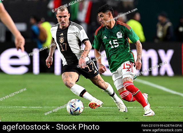 18 October 2023, USA, Philadelphia: Soccer: Internationals, Mexico - Germany, Lincoln Financial Field. Germany's David Raum (l) and Mexico's Carlos Antuna fight...