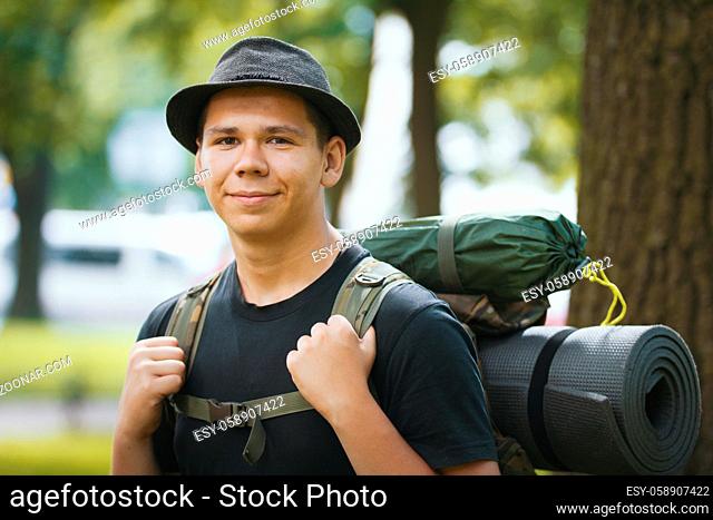 Portrait of a young man tourists in hat with backpack outdoor, horizontal shot