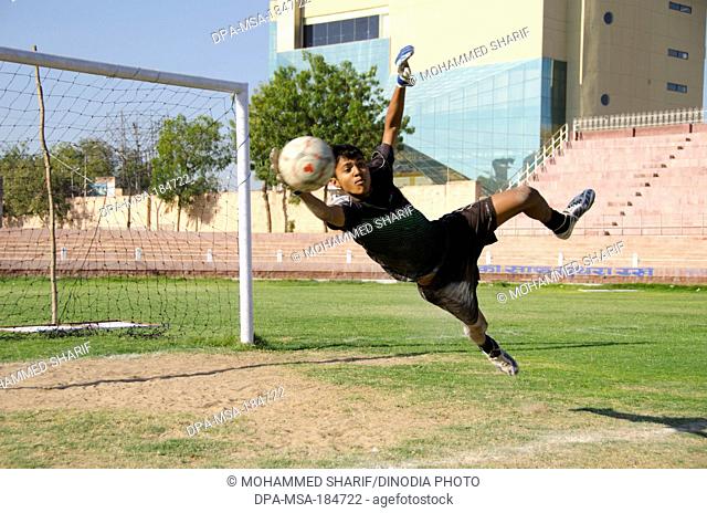 Goalkeeper stopping ball in soccer game at Jodhpur India