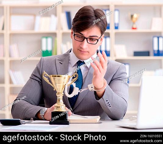 The businessman with golden cup in the office