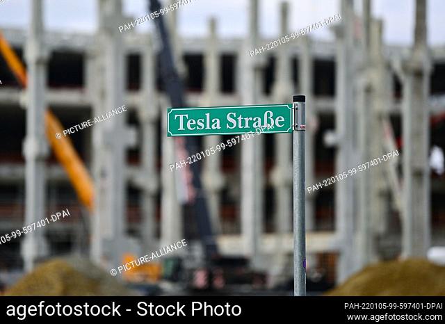 05 January 2022, Brandenburg, Grünheide: The street sign ""Tesla Straße"" stands at the construction site of the Tesla Gigafactory Berlin Brandenburg with the...