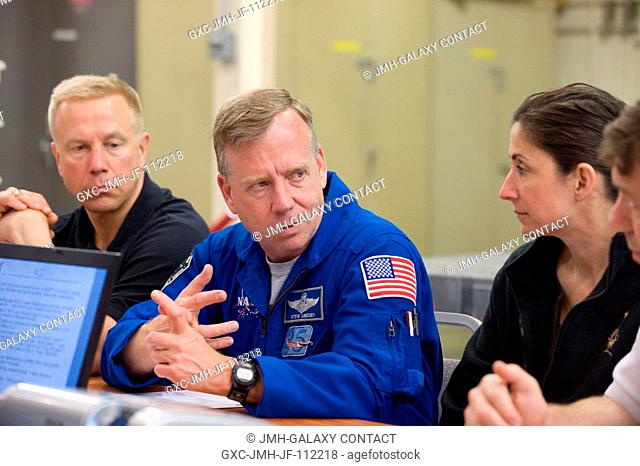 NASA astronauts Steve Lindsey (center), STS-133 commander; Tim Kopra (left), Nicole Stott and Michael Barratt (mostly out of frame), all mission specialists