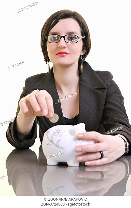 young business woman iosolated on white putting coins money in piggy bank and representing concept of saving and smart spending money