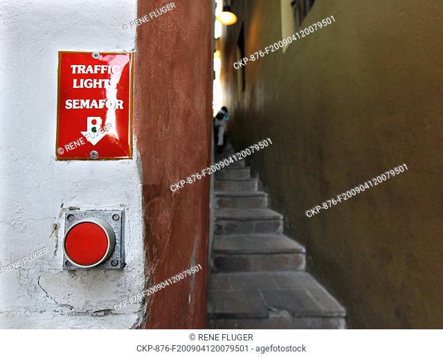 A person passes the narrowest street in Prague, Mala Strana, Apr 12, 2009 This street is not even 50 cm large and the traffic is coordinated by the traffic...
