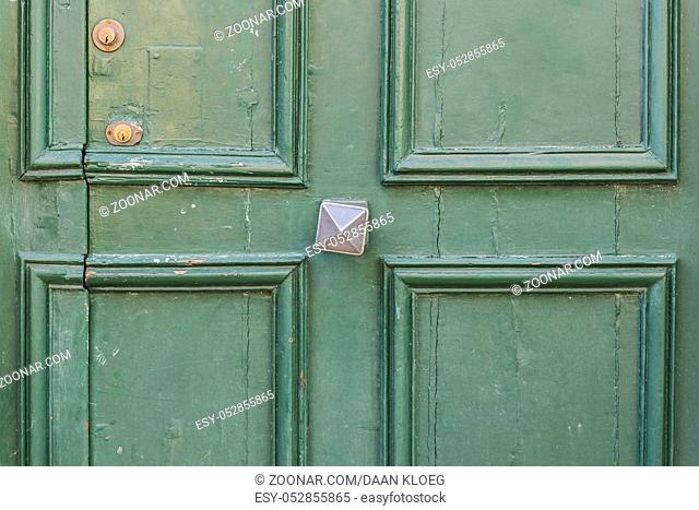 Old green door with door handle in Nevers in France