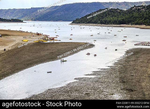 11 August 2022, France, Aiguines: Canoes and SUPs paddle in the meager remnant of the Verdon River at the head of the Lac de Sainte-Croix reservoir