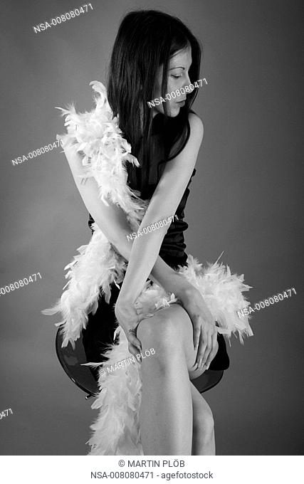 young woman with feather boa on bar stool