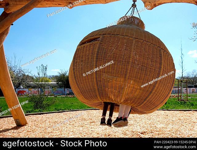 23 April 2022, Torgau, Sachsen: Children sit in a swing basket on the grounds of the 9th Saxon State Garden Show. This was opened earlier