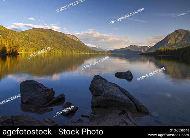 Early morning light bathes Lake Wenatchee in sunshine, on a calm, quiet spring day, making it an attrative vacation destination