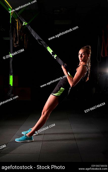 One women doing push ups training arms with straps Total Resistance eXercises fitness straps in the gym Concept workout healthy lifestyle sport
